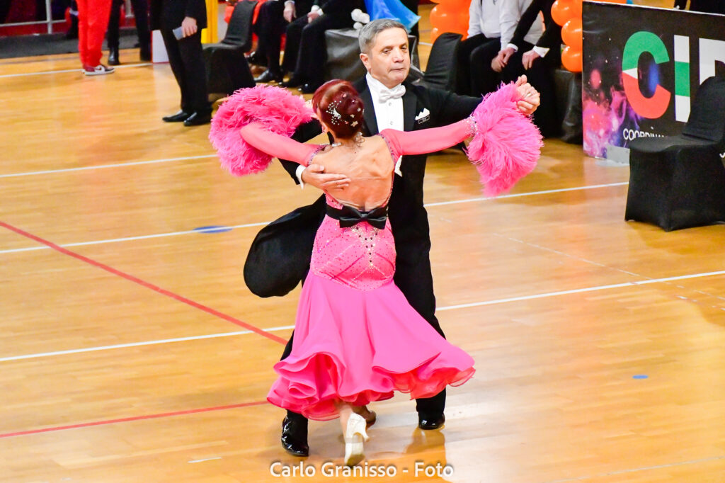 Coppia di ballerini in abiti da ballo esegue una coreografia raffinata durante la competizione Union Dance Open per il ballo da sala.