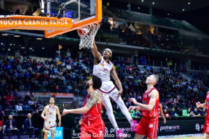 Paul Eboua di Trapani Shark si eleva al ferro contro la difesa di Pallacanestro Trieste nei quarti di finale delle Final Eight 2025.