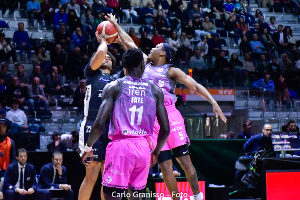 Anthony Lamb di Dolomiti Energia Trentino tenta un tiro contestato da due difensori di UNAHOTELS Reggio Emilia nei quarti di finale delle Final Eight 2025.